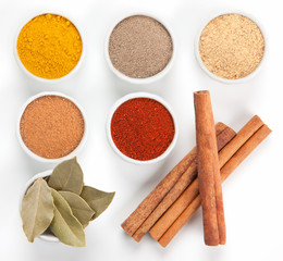  Different spices in white bowls isolated on white background.