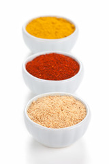 Different spices in white bowls isolated on white background.