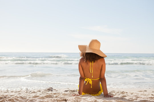 Young attractive woman looking at the ocean while sunbathing