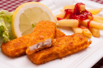 Panierte Fischstäbchen mit Zitrone und grünem Salat