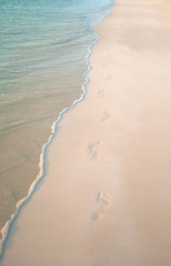FOOTPRINTS ON THE BEACH SAND