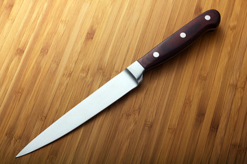 chef's knife on wood cutting board