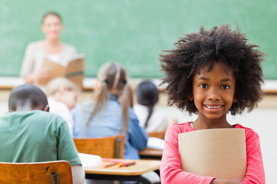 Smiling girl standing in classroom