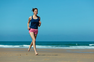 Fototapeta na wymiar Girl running on the beach in barefoot