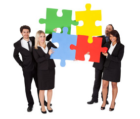 Group of business people assembling puzzle
