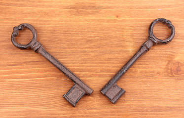 Two antique keys on wooden background