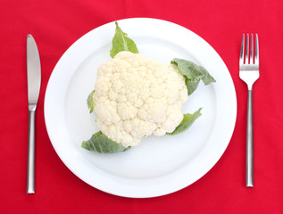 Fresh cauliflower on plate, knife and fork