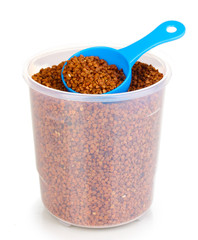 Measuring spoon and plastic container with grain isolated