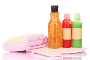 Bottles with scrub and sponges isolated on white