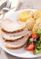 slice of roast pork and vegetables