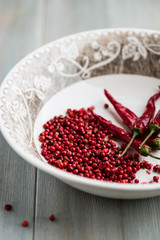Pink peppercorns and dried chili peppers in a bowl