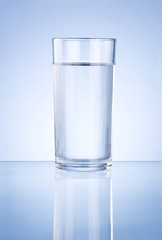 Glass of water on blue background