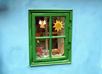 green window with decorations on a cyan wall