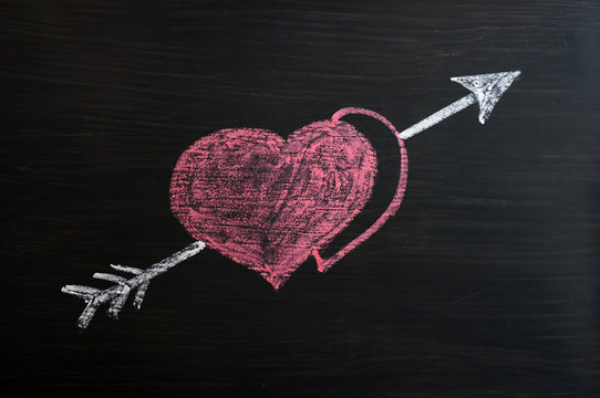 Love hearts with Cupid arrow on a chalkboard