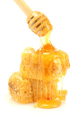 golden honeycombs and wooden drizzler with honey isolated