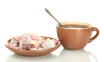 A cup of tea and saucer with delicious turkish delight isolated