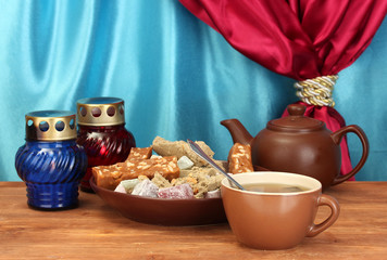 Teapot with cup and plate with oriental sweets - sherbet, halva