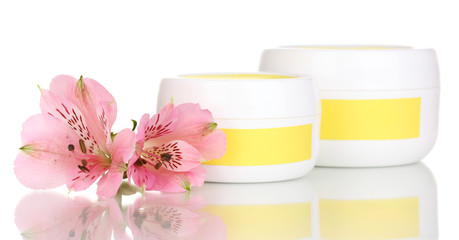 Jars of cream with flower isolated on white
