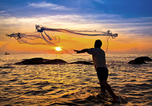 throwing fishing net during sunset , thai