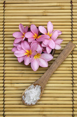 Fototapeta na wymiar frangipani and Green salt in wooden spoon on mat