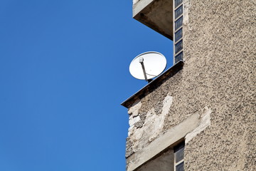 Balcon avec parabole. Ciment et ciel bleu.