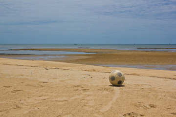 old soccer ball on beach