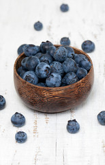 bowl with fresh blueberries on wooden table