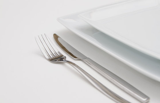 Dinner place setting. white  plates with silver fork and knife