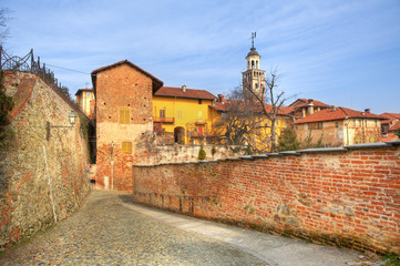 Old houses and paved street in Saluzzo, Italy.
