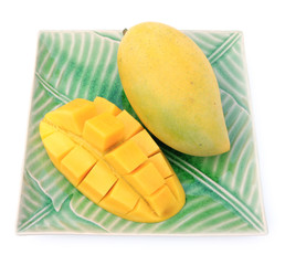 Yellow mango on plate on white background