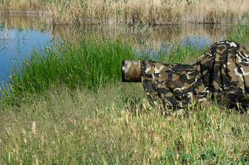 Bird photographer taking photos with camouflaged telephoto lens