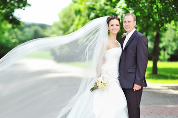 Portrait of happy bride and groom in a park