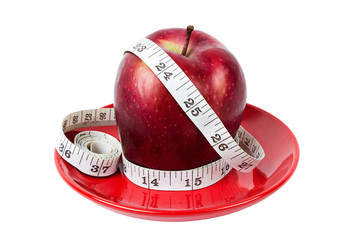 Dieting concept Red apple with measuring tape on red plate