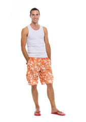 Full length portrait of on vacation smiling young man in shorts