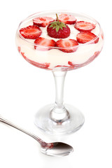 Glass of ripe strawberries with cream isolated on white