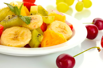 Fresh fruits salad on plate and berries isolated on white