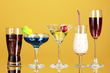 a variety of alcoholic drinks on yellow background