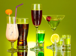 a variety of alcoholic drinks on green background