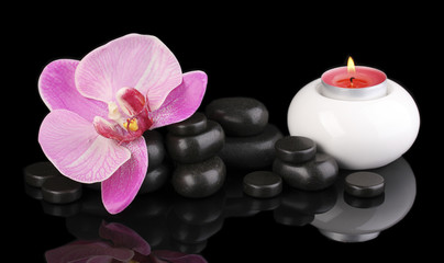 Fototapeta na wymiar Spa stones with orchid flower and candle isolated on black