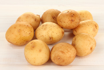 young potatoes on white wooden table close-up