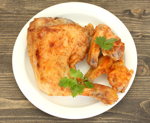 roasted chicken wings and leg with parsley in the plate