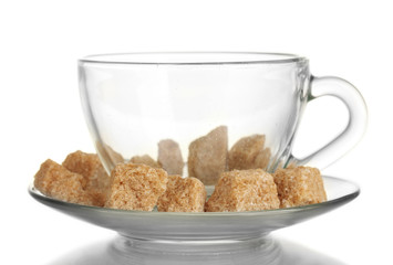 Lump brown cane sugar cubes in glass cup isolated on white