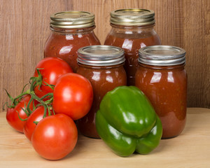 Tomato sauce in jars with tomatoes and peppers
