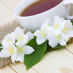Fototapeta na wymiar Cup of jasmine tea and jasmine flowers