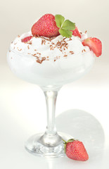 glass of ripe strawberries with cream isolated on white