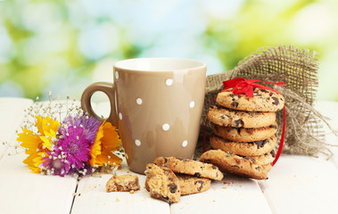 cup of milk, chocolate chips cookies with red ribbon and