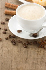 Obraz na płótnie Canvas cup of coffee and beans on wood