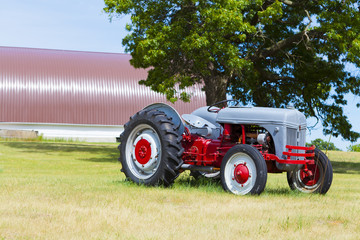 Obraz premium Tractor with big farm in the background