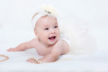 Portrait newborn baby lying in bed with a pearl necklace