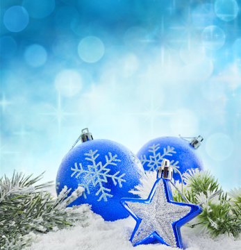 Christmas branch of tree blue baubles and snow background